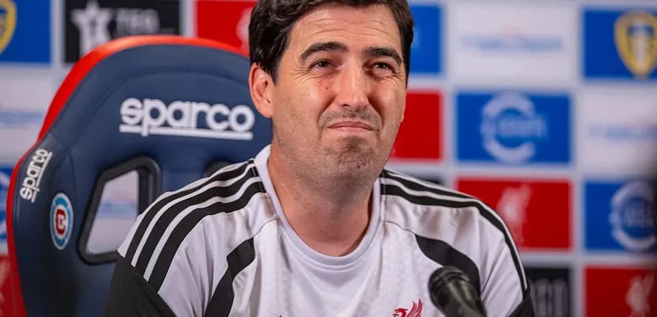 Manager at press conference with Liverpool branding