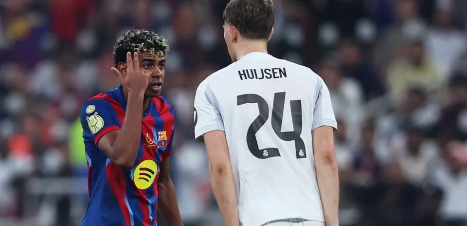 Barcelona player gesturing at Real Madrid opponent