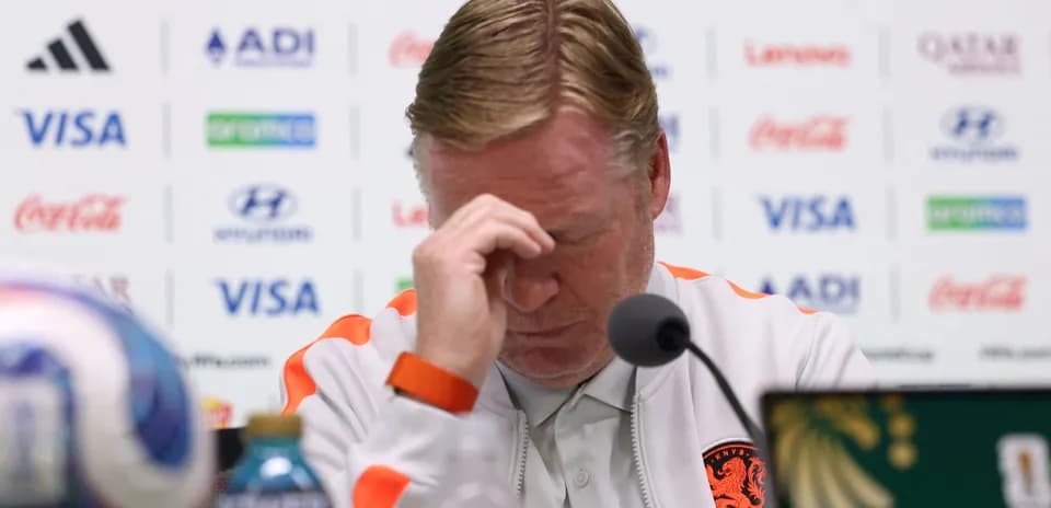 Coach at press conference with hand on forehead