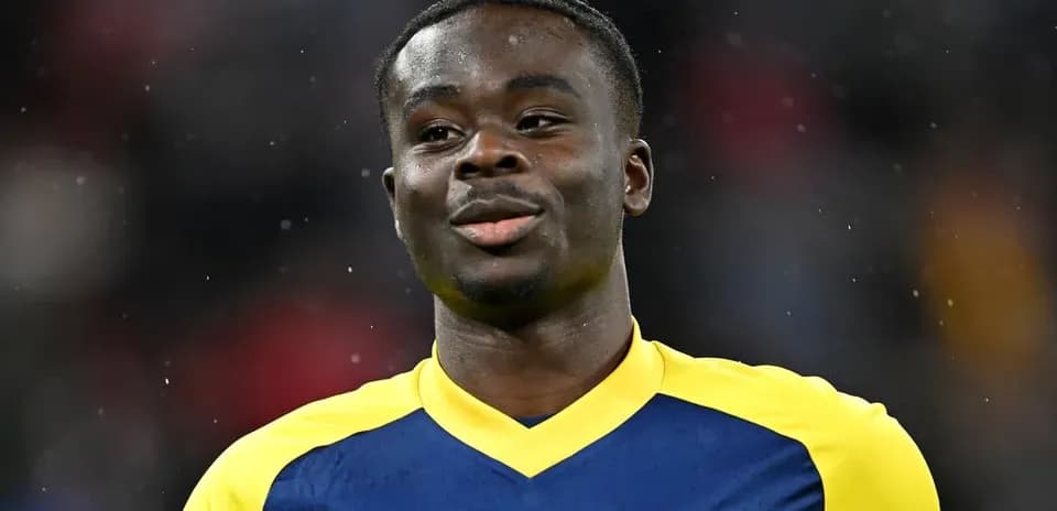 Player in Arsenal jersey smiling on the field