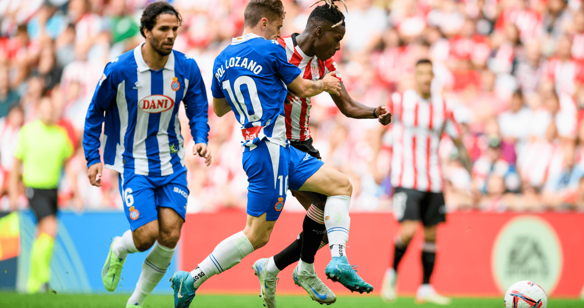 Espanyol player challenging Athletic Club opponent
