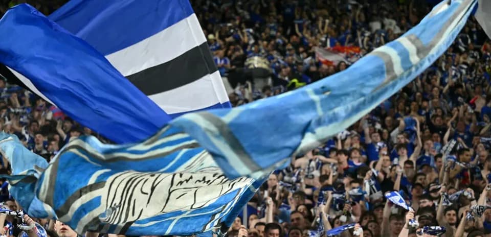 Fans waving flags and scarves in stadium