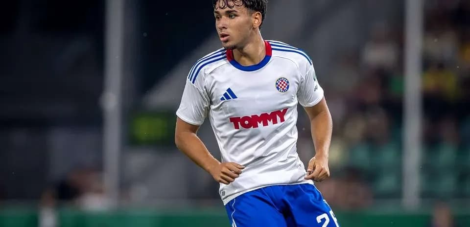 Player in action wearing white and blue kit