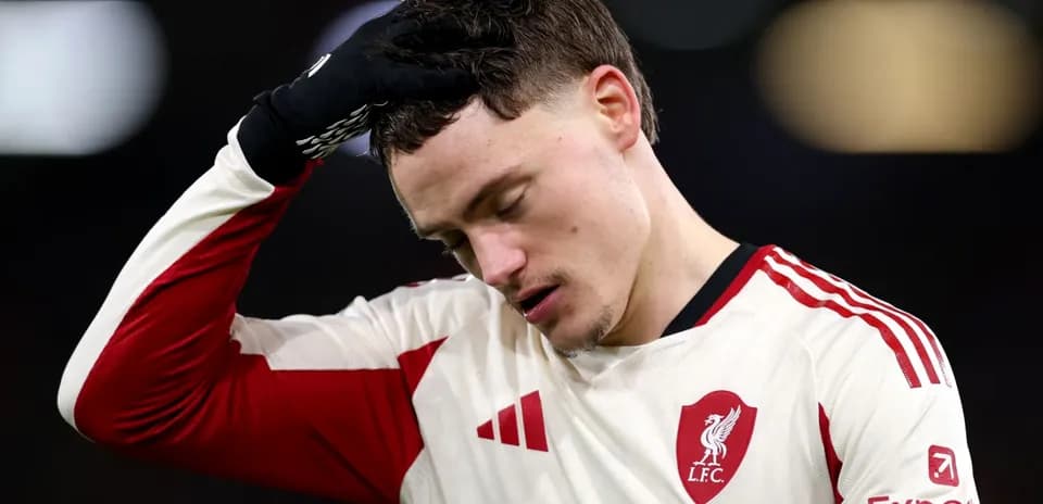 Player in Liverpool kit looks disappointed on field