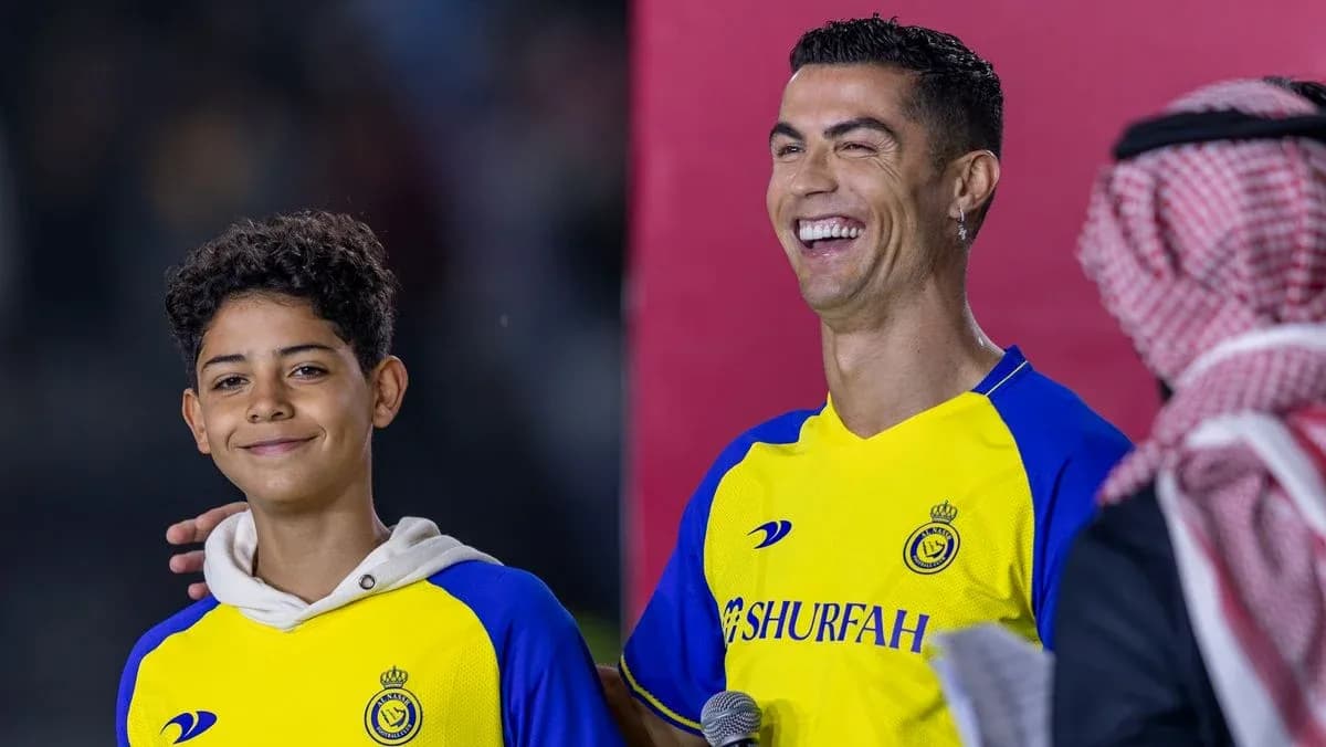Cristiano Ronaldo smiling with young fan on stage