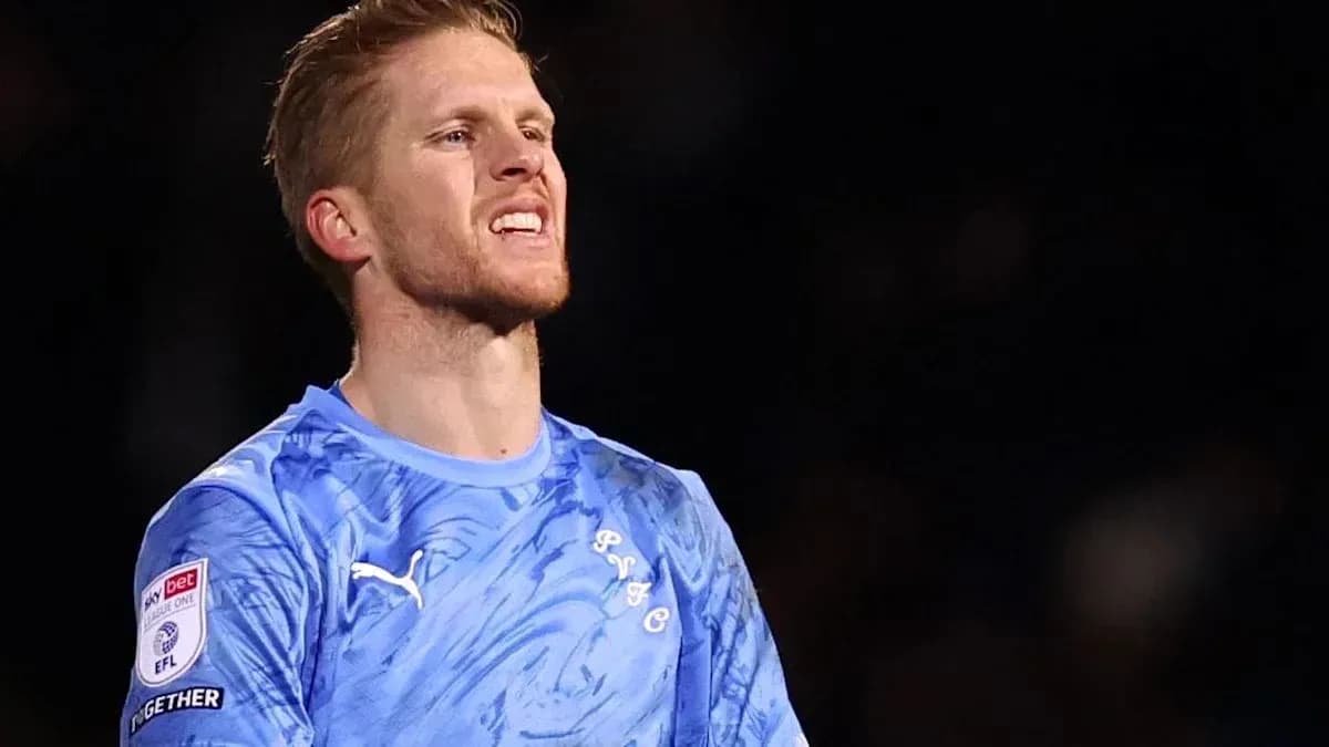 Goalkeeper in blue kit during match action