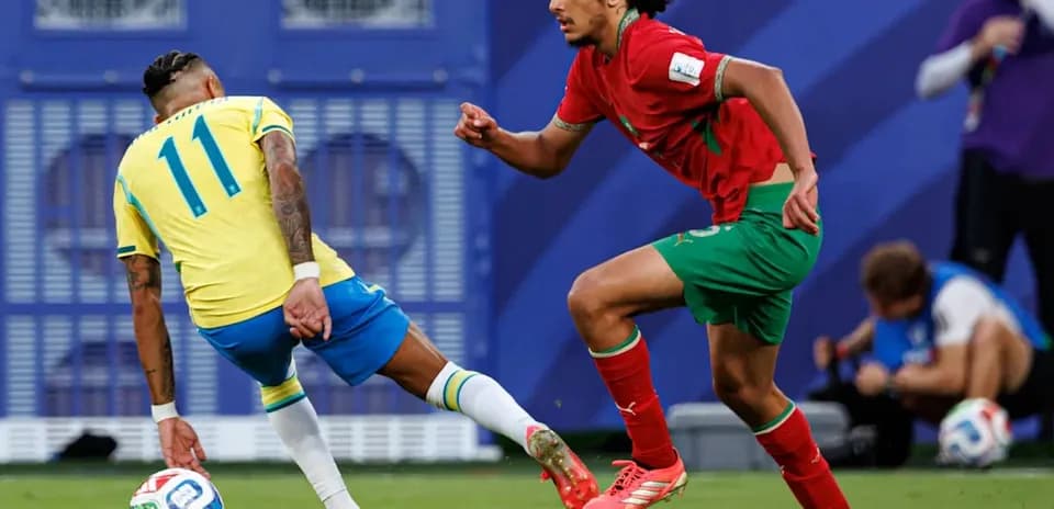 Brazilian player dribbling past Moroccan defender on field