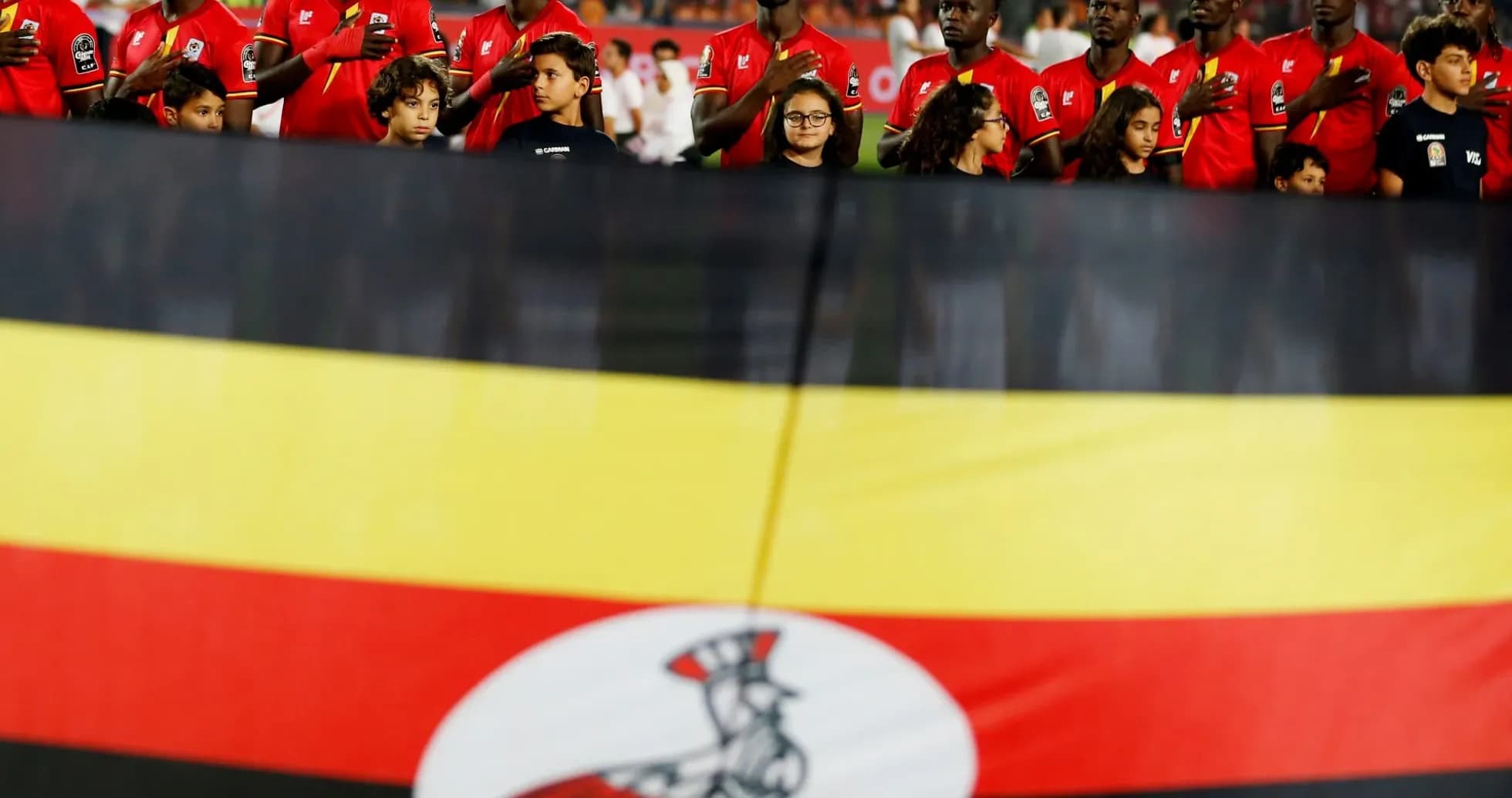 Players and children with Ugandan flag during anthem