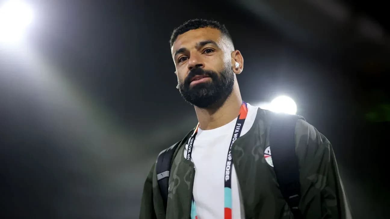 Player walking with headphones and backpack in stadium