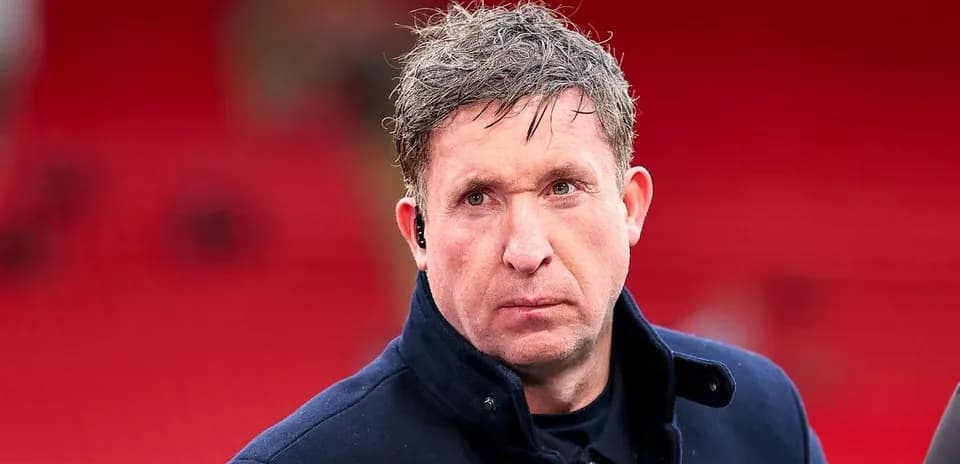 Man in dark coat with earpiece at stadium