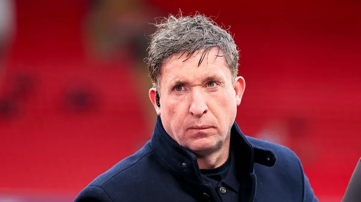 Man in dark coat with earpiece at stadium
