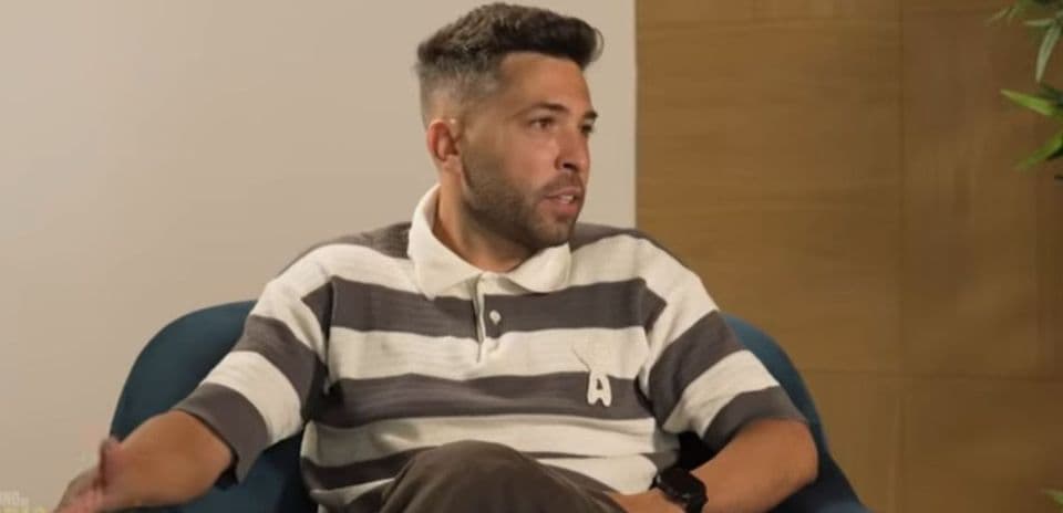 Man speaking during an interview seated on a couch