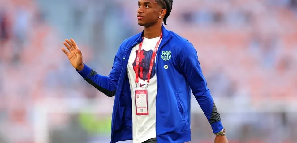 Player waving while wearing a team jacket