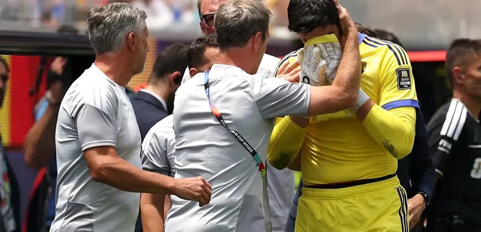 Goalkeeper receiving support from coaches on sidelines