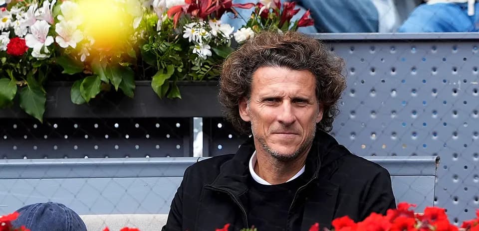 Man sitting among flowers at tennis event