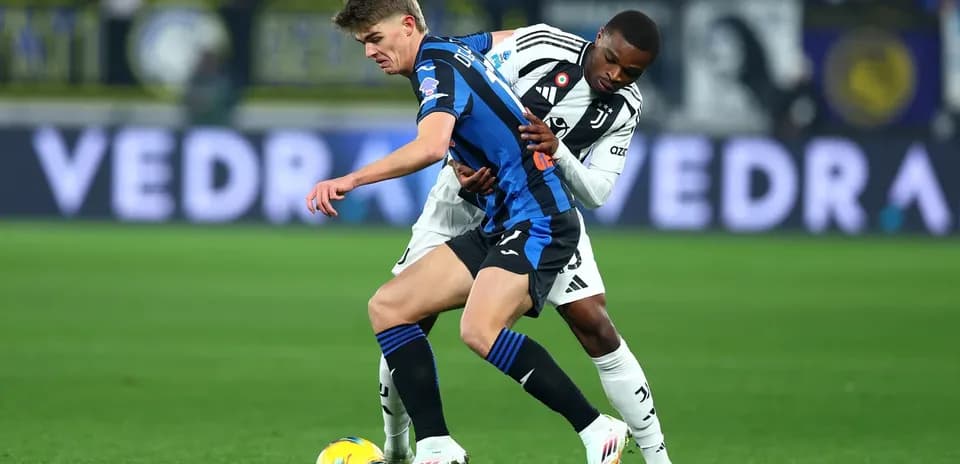 Juventus player tackling Atalanta opponent during match