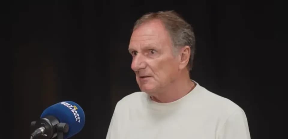 Person speaking at a microphone during interview