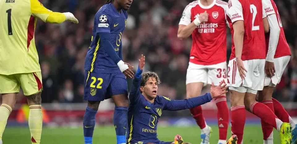 Atletico Madrid player on ground, Arsenal players nearby