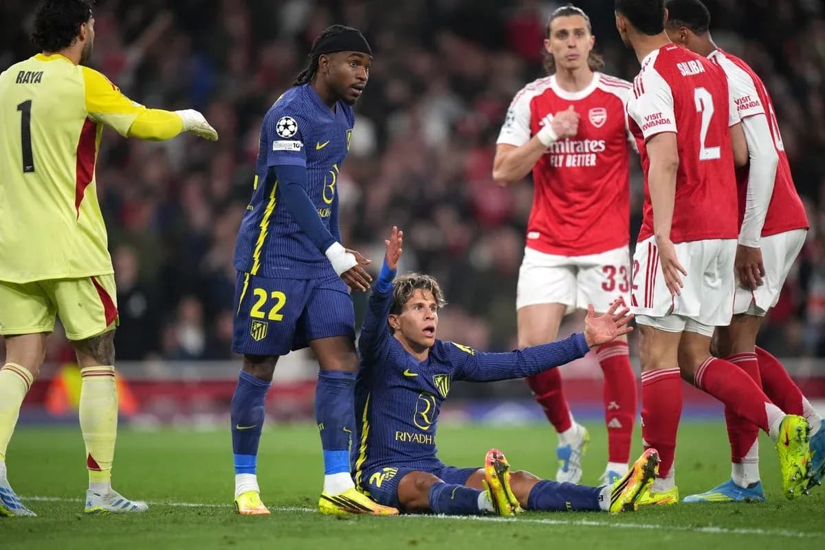 Atletico Madrid player on ground, Arsenal players nearby