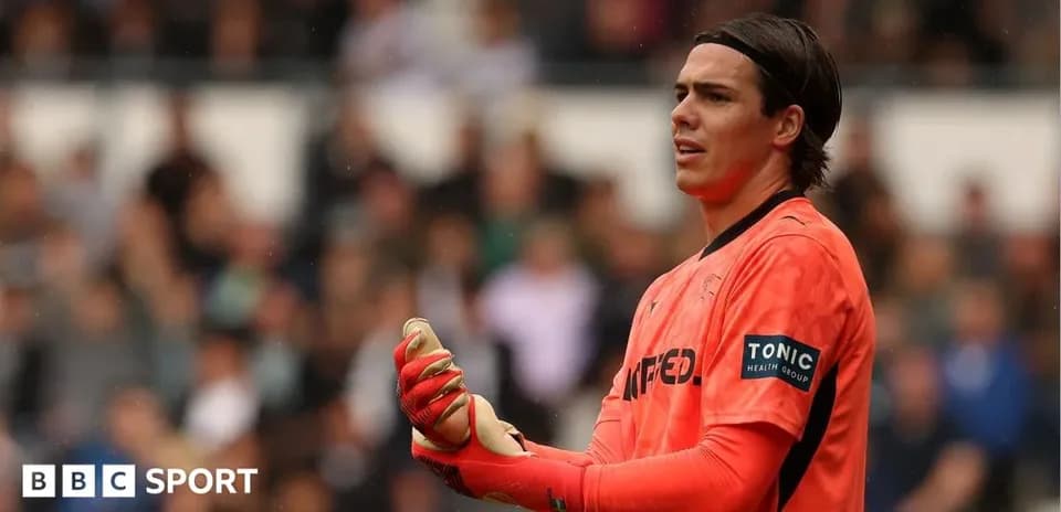 Goalkeeper in orange kit during match action