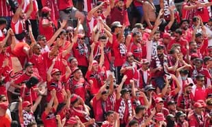 Crowd of fans cheering in red jerseys and scarves