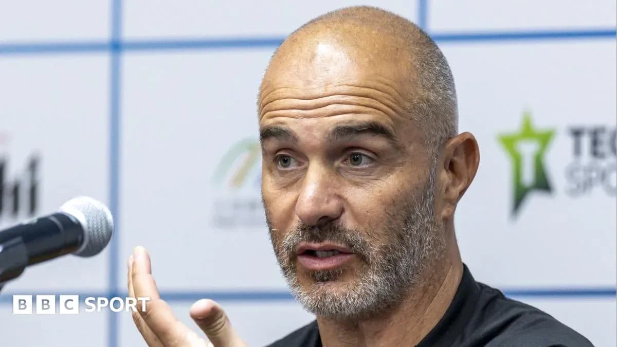 Coach speaking at press conference with microphone