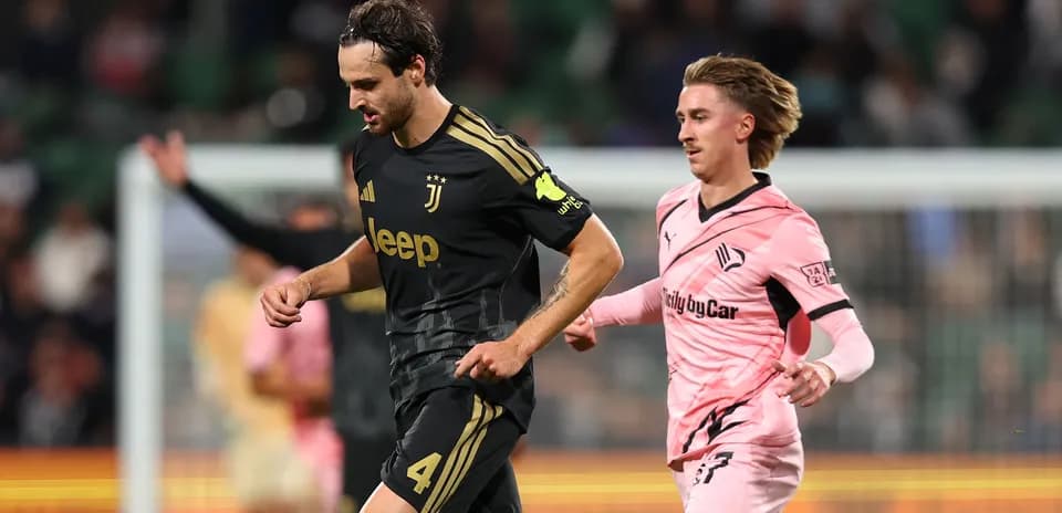 Juventus player running with ball pursued by opponent