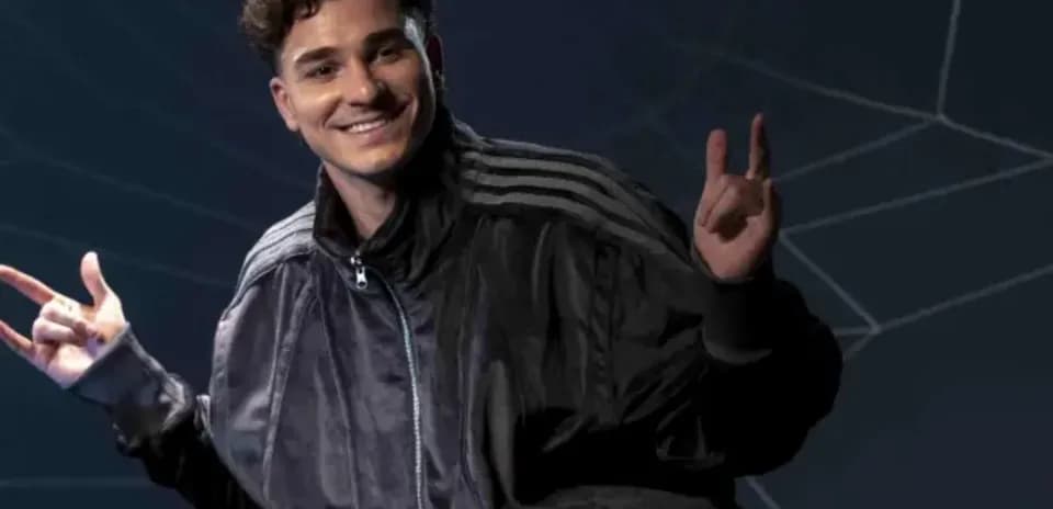 Person posing with hand gestures against dark background
