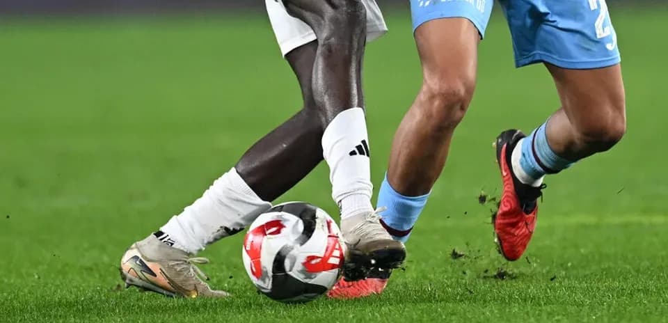 Two players contesting for the ball on field