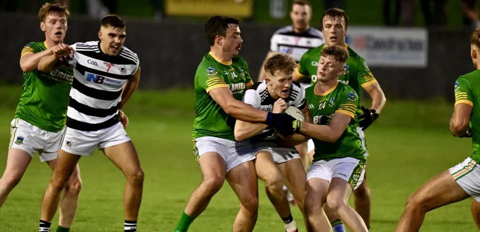 Players competing for possession during Gaelic football match