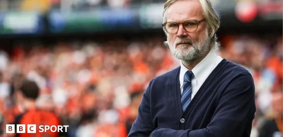 Coach observing match with arms crossed on sidelines
