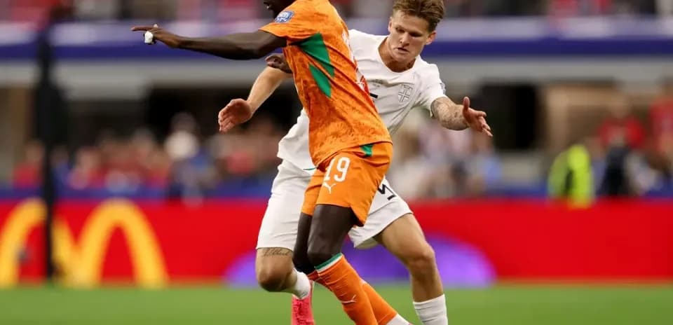 Player in orange jersey evading opponent in white jersey
