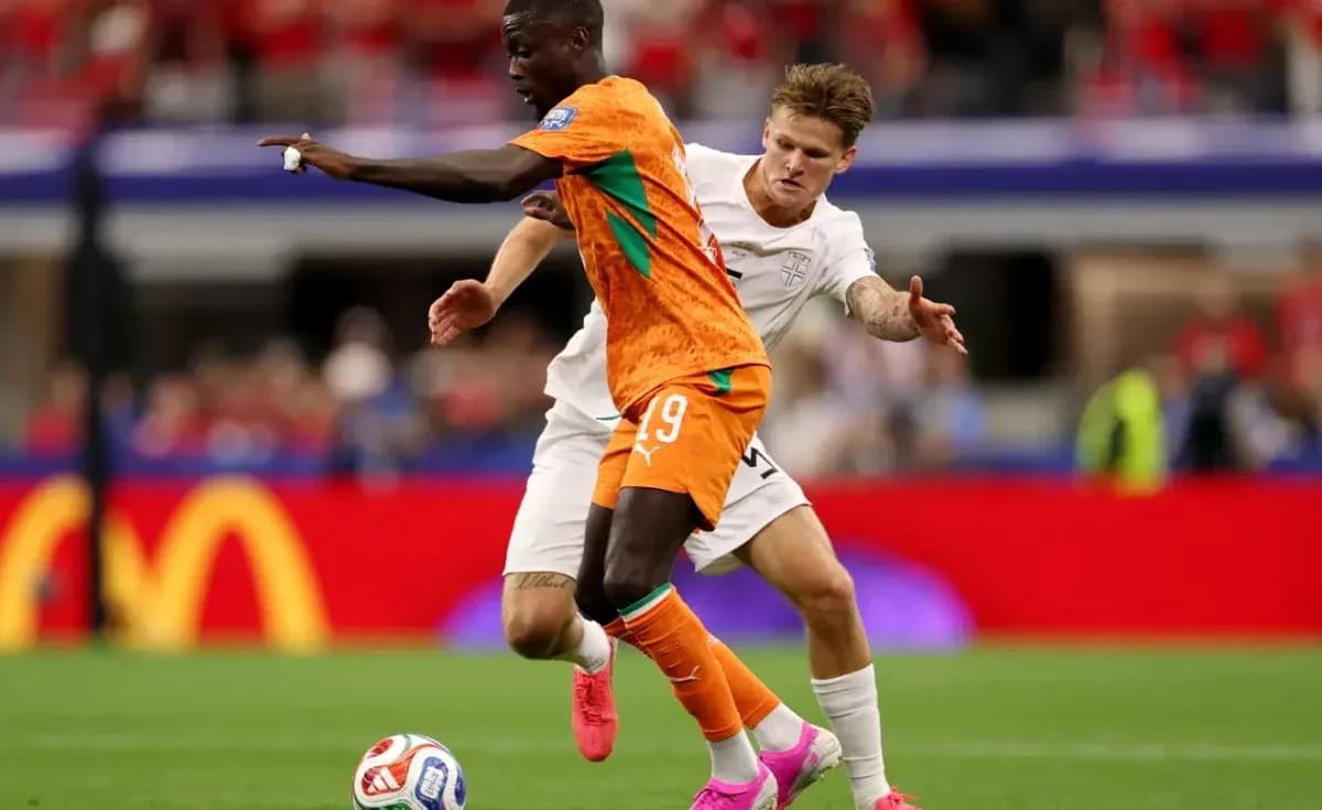 Player in orange jersey evading opponent in white jersey