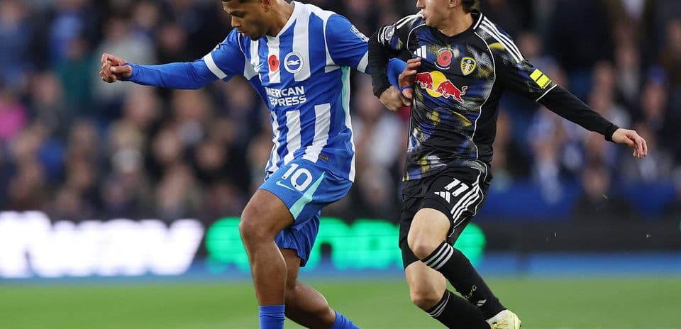 Brighton player dribbling past Leeds opponent