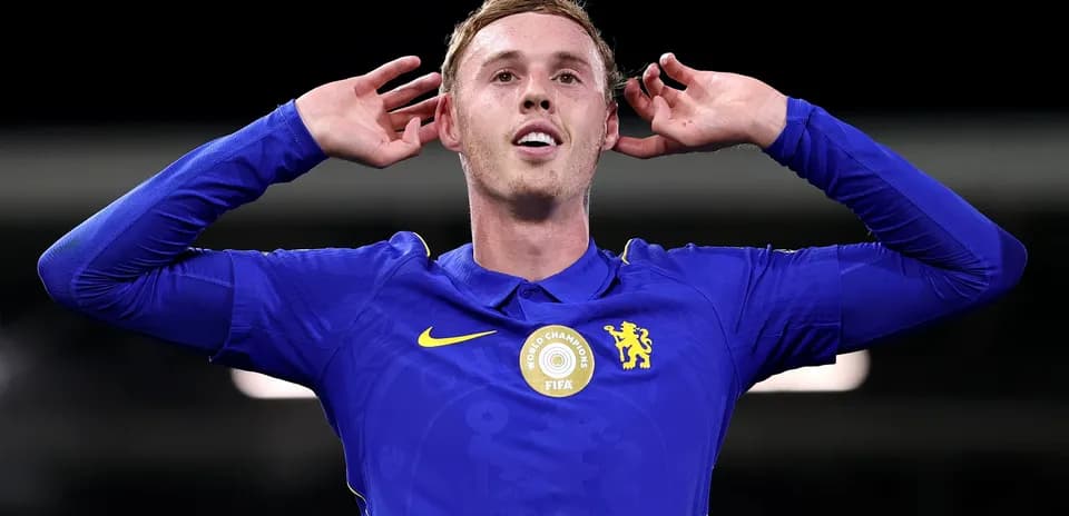 Player celebrating in Chelsea's blue kit with hands raised