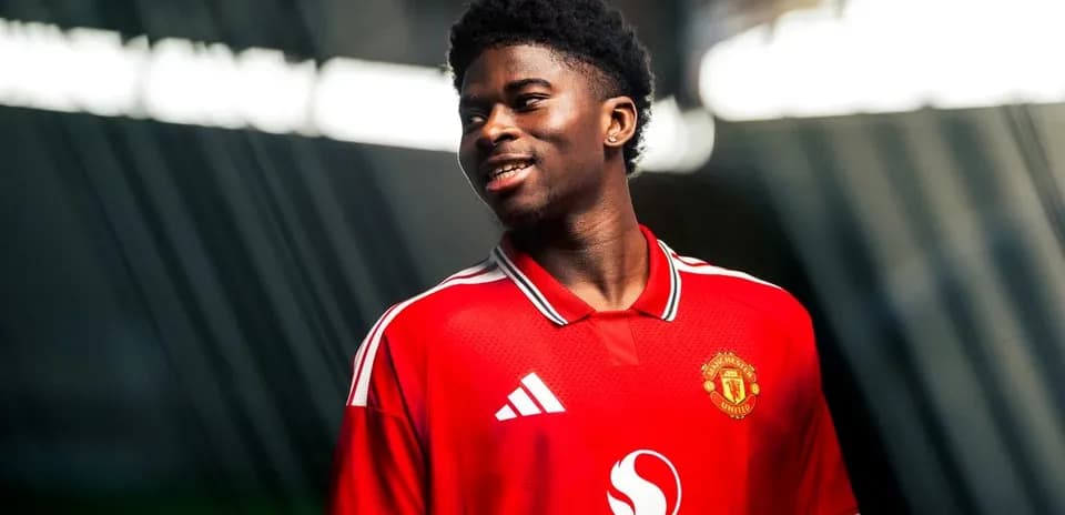 Player in Manchester United jersey smiling for photo