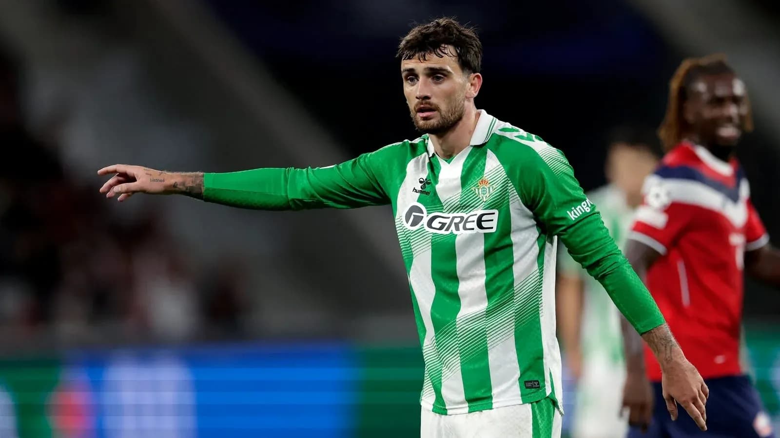 Player in green jersey gesturing during match