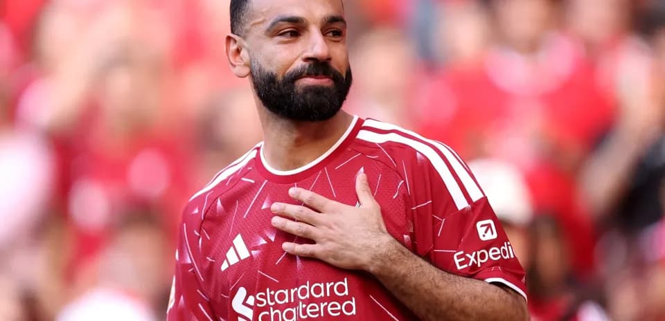 Player in red jersey gestures to crowd at stadium