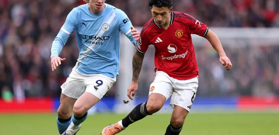 Manchester United player dribbling past Manchester City opponent