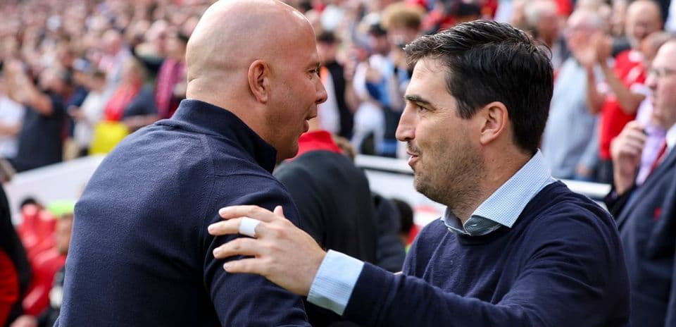 Two coaches greeting each other before the match