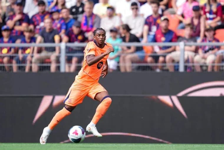 Player in orange kit running on the field