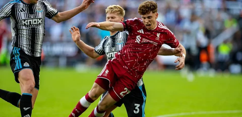 Newcastle players challenging Liverpool player on pitch