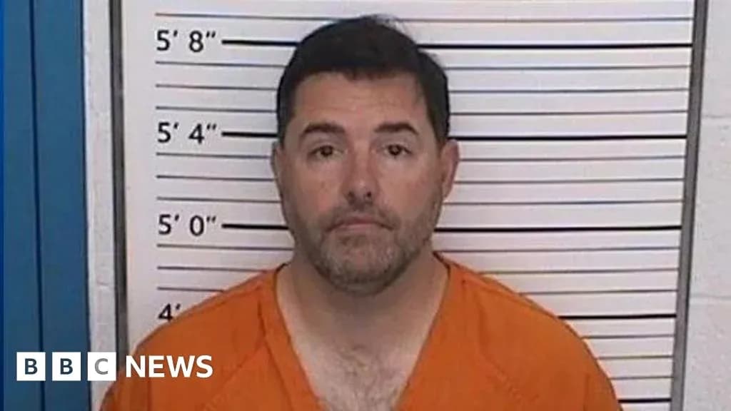 Man in orange jumpsuit standing against height chart