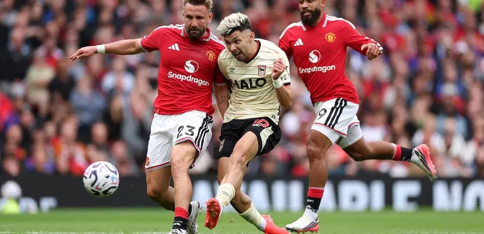 Manchester United players tackling Ipswich forward