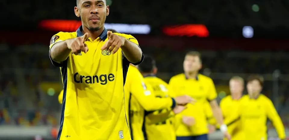 Player celebrating with teammates in yellow jerseys