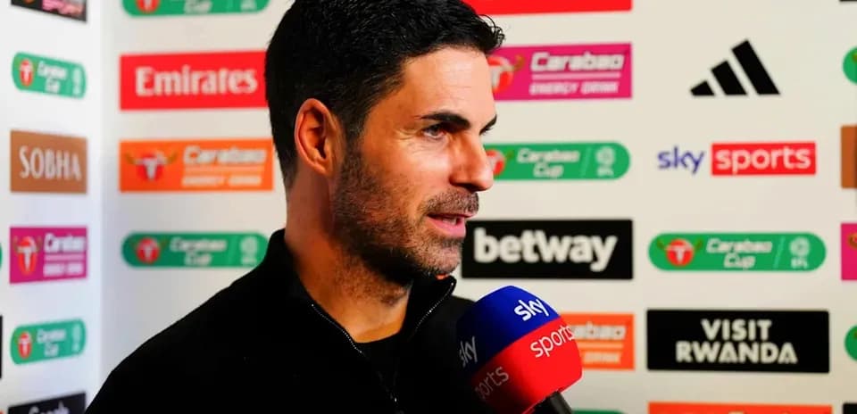 Manager speaking during press conference with sponsor backdrop