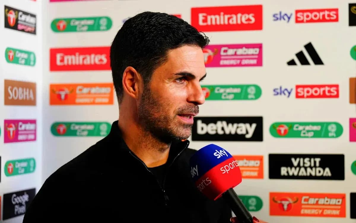 Manager speaking during press conference with sponsor backdrop
