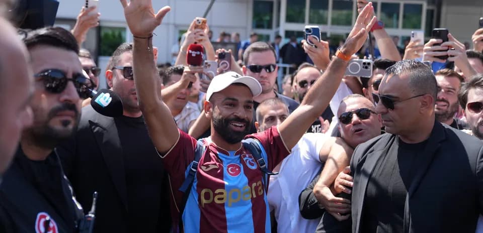 Player greeting fans while surrounded by supporters