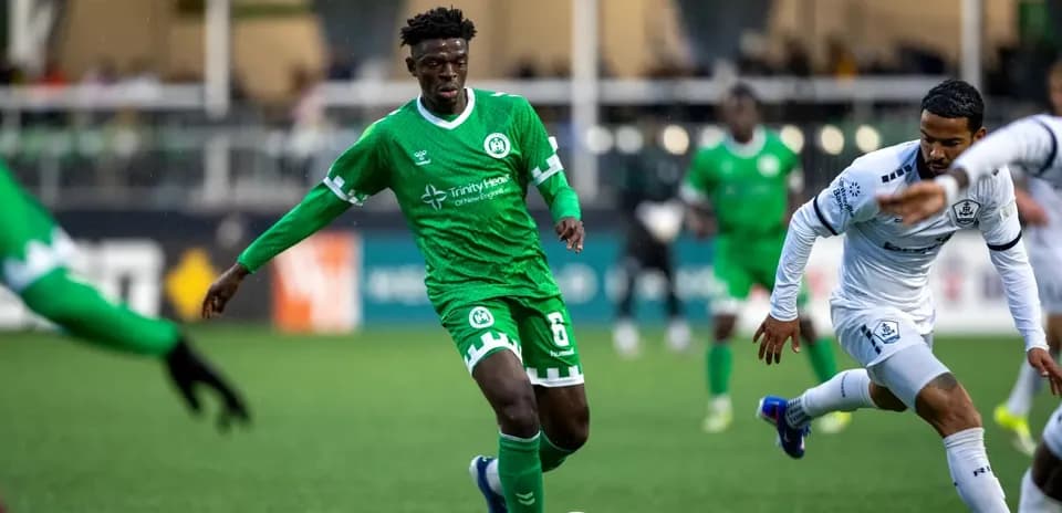 Player in green jersey dribbling ball during match