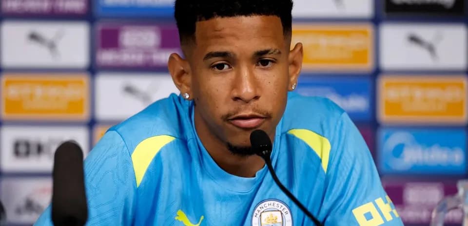 Player at press conference wearing Manchester City kit